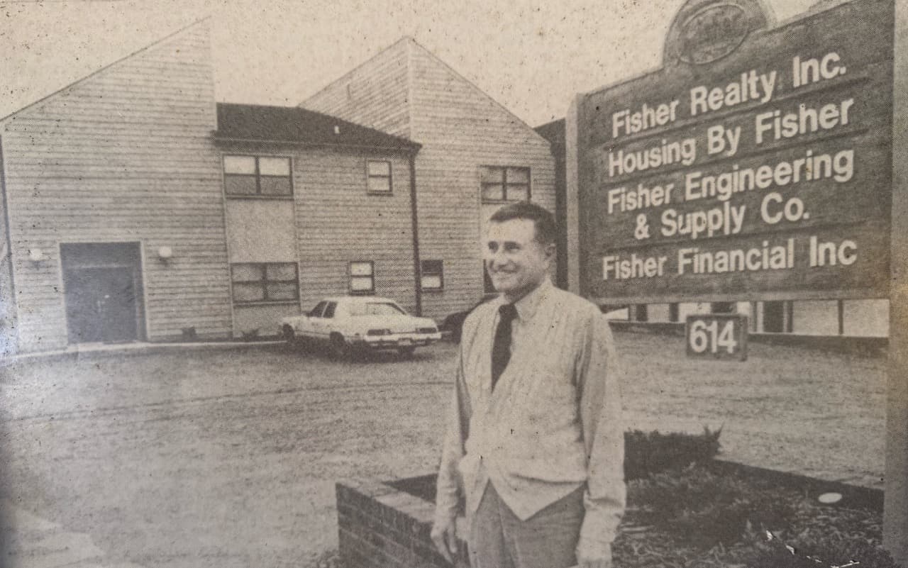 Historic office photo featuring Carrol Fisher with company leadership